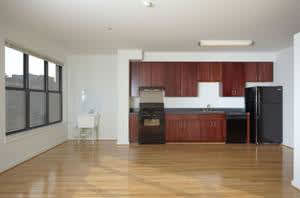 A kitchen with a black fridge and a black oven.