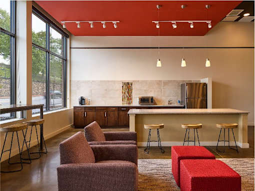A modern room with a bar and seating area.