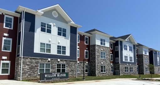 Exterior of building with signage in front with community name
