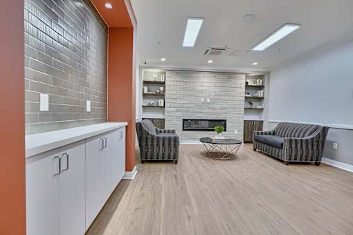 A living room with a fireplace and two chairs.