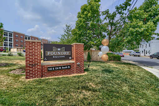 A sign for Foundry Square is in front of a grassy area.
