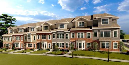A large, multi-story residential building with a brick facade and multiple windows.