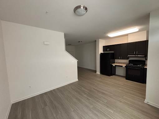 A kitchen area with a stove top oven and a refrigerator.