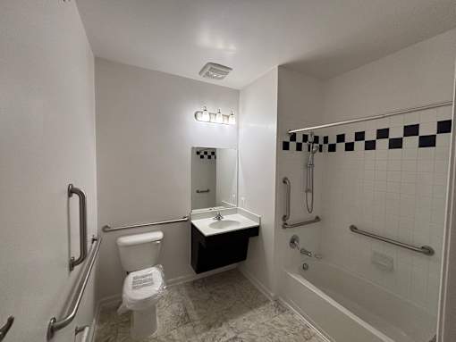 A white bathroom with a toilet, sink, and bathtub.