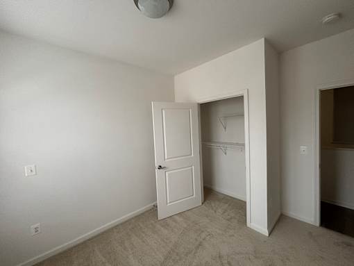 A white door is open in a room with a light colored carpet.