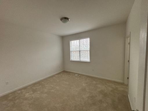 A room with a window and a ceiling light.