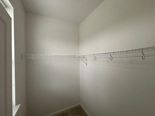 A white closet with a metal rack on the wall.