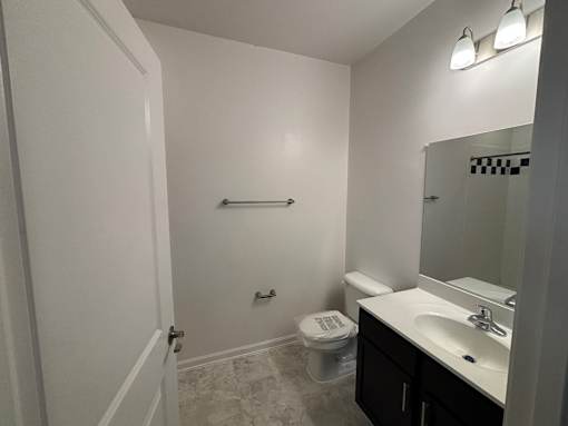 A bathroom with a toilet, sink, and mirror.