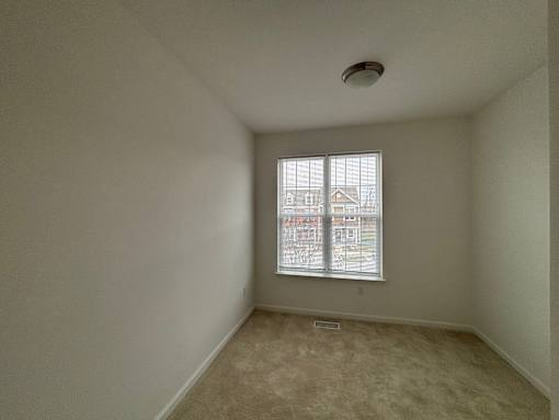 A room with a window and a ceiling fan.