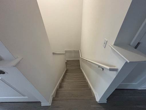 A staircase with a white railing and wooden steps.