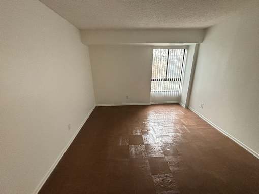 A room with brown flooring and white walls.