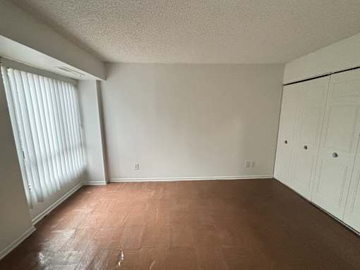 A room with wooden flooring and white walls.