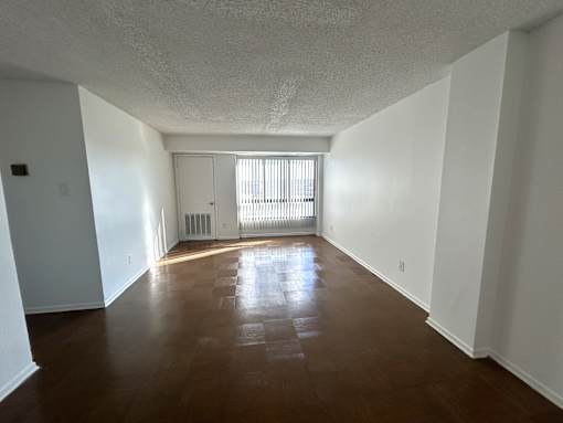 A room with wooden flooring and white walls.