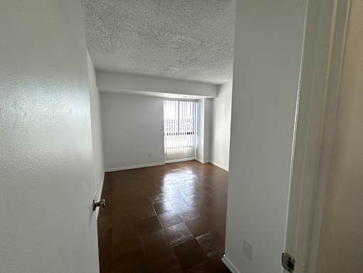 A room with white walls and a wooden floor.