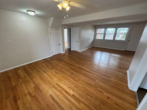 A room with wooden flooring and white walls.