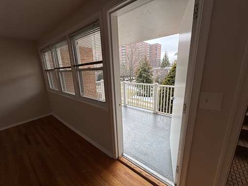 A room with a view of a balcony and buildings outside.
