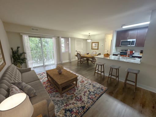 a view of a living room and a kitchen with a table and chairs