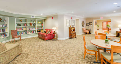 A living room with a sofa, chairs, and a bookshelf.