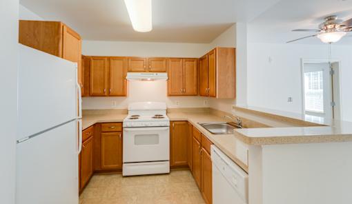 A kitchen with wooden cabinets and white appliances.