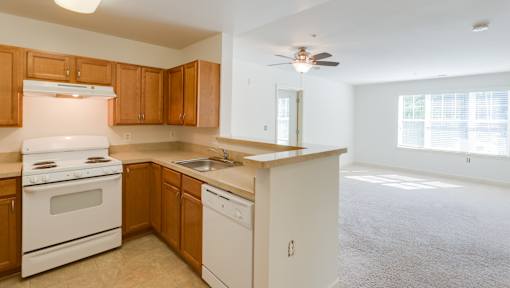 A kitchen with white appliances and wooden cabinets.