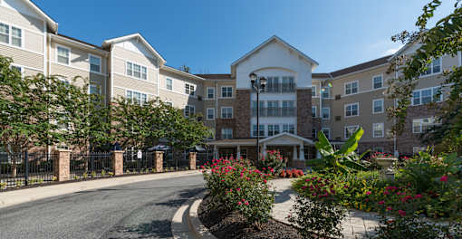 A street view of a residential area with apartment buildings and landscaped gardens.