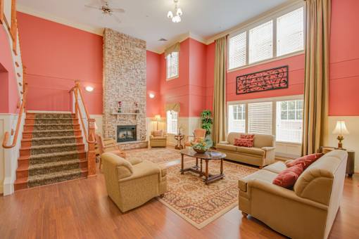 A living room with a fireplace and a staircase.