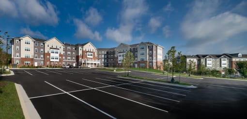 an empty parking lot in front of an apartment building