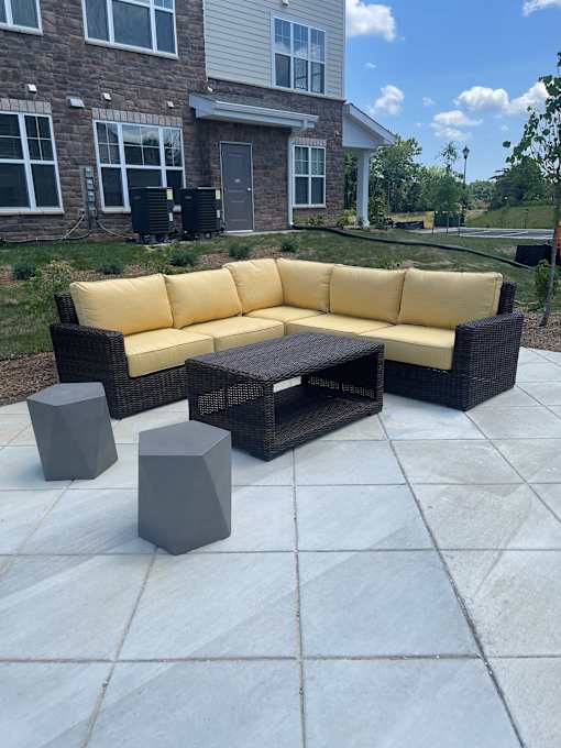 A yellow couch and black coffee table on a patio.