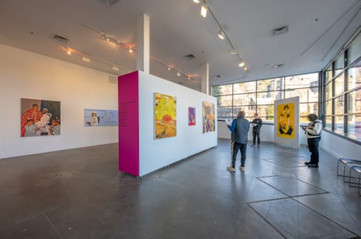 People are looking at artwork on display in a gallery.
