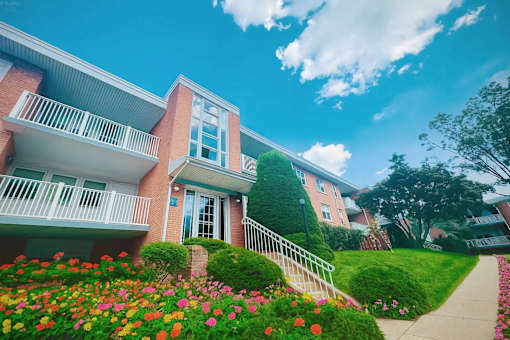 A row of houses with a flower bed in front of them.