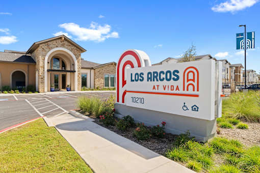 a building with a sign that says los arcos at vida