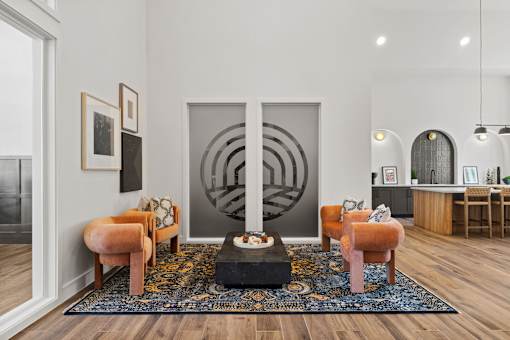 Resident lounge featuring comfortable seating, contemporary design finishes, and adjacent gathering space for socializing and relaxation.