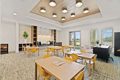 A room with a fireplace and a long table with chairs.