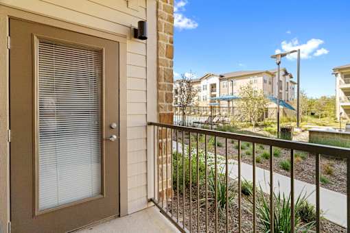 a view from a porch with an apartment in the distance