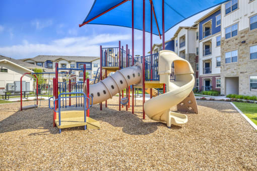a playground with a slide at an apartment complex