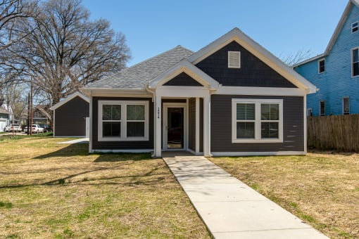 a gray house with a sidewalk in front of it