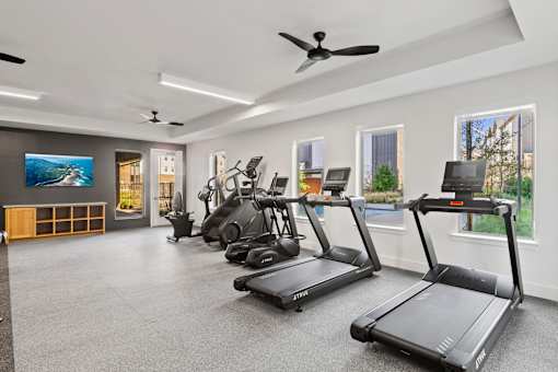 Resident fitness center featuring cardio and strength-training equipment in a modern, spacious workout environment.