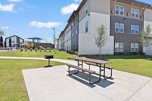 A picnic table in a grilling area.