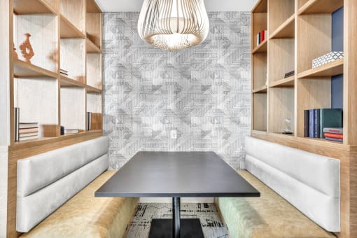 a dining room with a black table and a wall with shelves