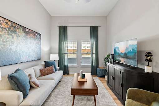 Apartment living room featuring comfortable seating, abundant natural light, and contemporary interior finishes.