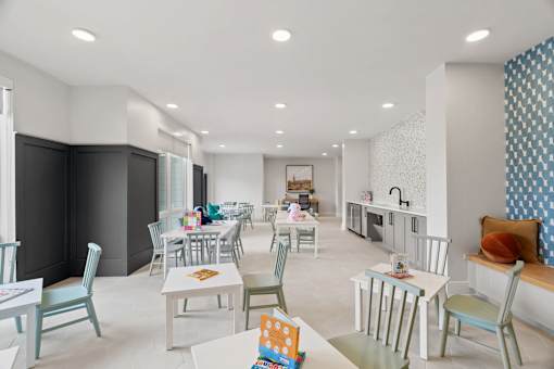 Family-friendly community room with activity tables, built-in seating, and dedicated space for games, crafts, and social interaction.