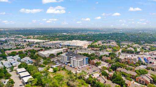 A bird's eye view of a city with buildings, roads, and trees.