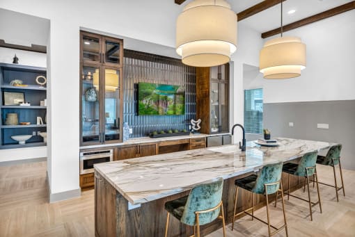 a modern kitchen with a long island with blue chairs