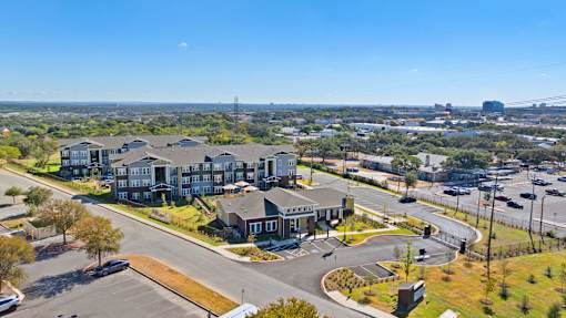 an aerial view of an apartment on a street with a city in the background