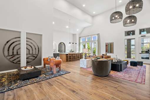 Resident clubhouse lounge featuring multiple seating areas, bar-height gathering space, and open-concept design for socializing and community events.