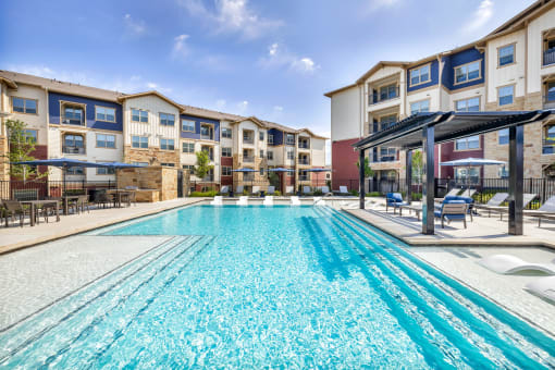 a swimming pool with an apartment building in the background