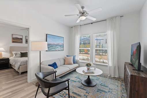 Apartment living room in at The Esther apartments with sofa, coffee table and a side chair.
