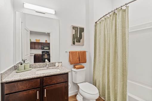 Modern bathroom at Aviator 1518 with dark wood vanity, mirror and shower.