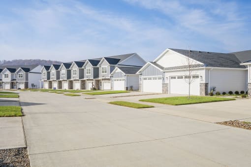 a row of white houses with blue roofs on a street