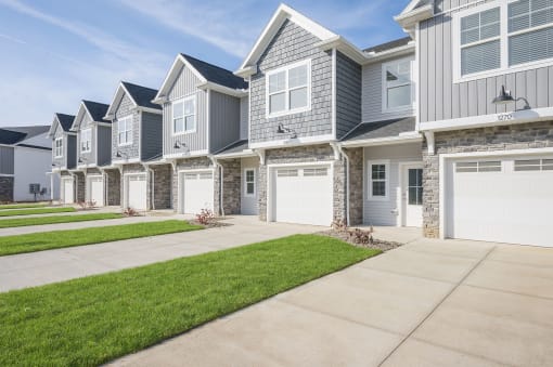a row of houses with white doors and a sidewalk
